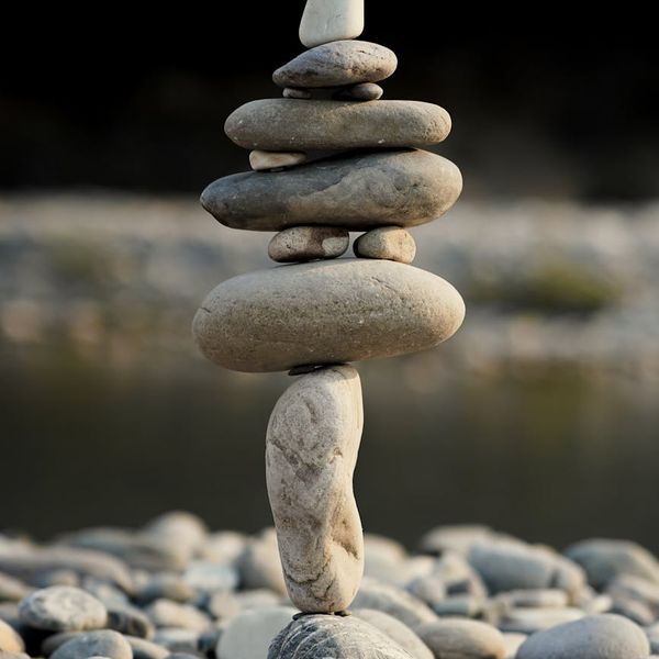 Smooth river stones stacked in a peaceful garden setting.